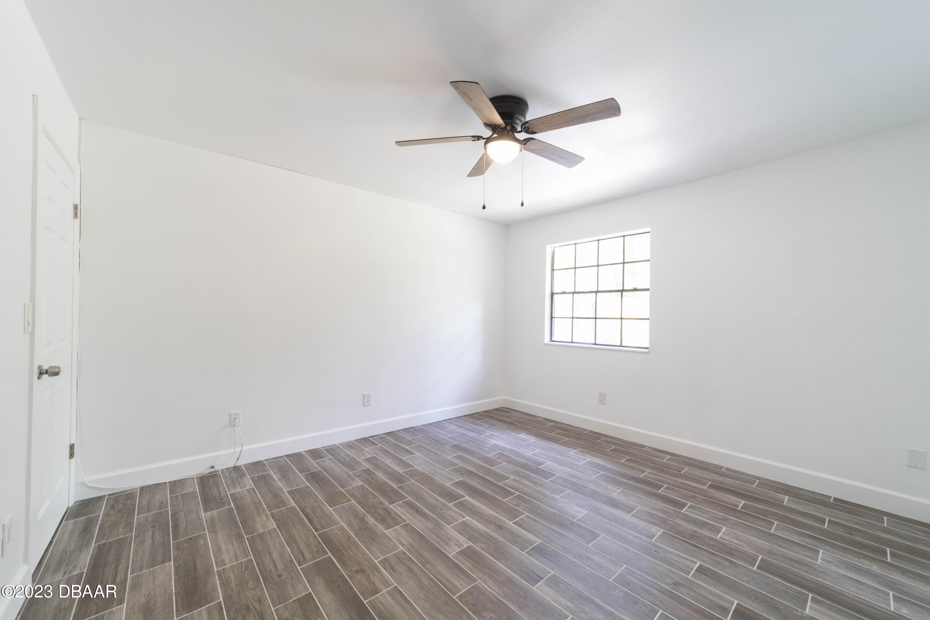 526 Live Oak Street, Unit 1050 Edgewater, FL 32132 - Photo 17 of 26 an empty room with wooden floor fan and windows
