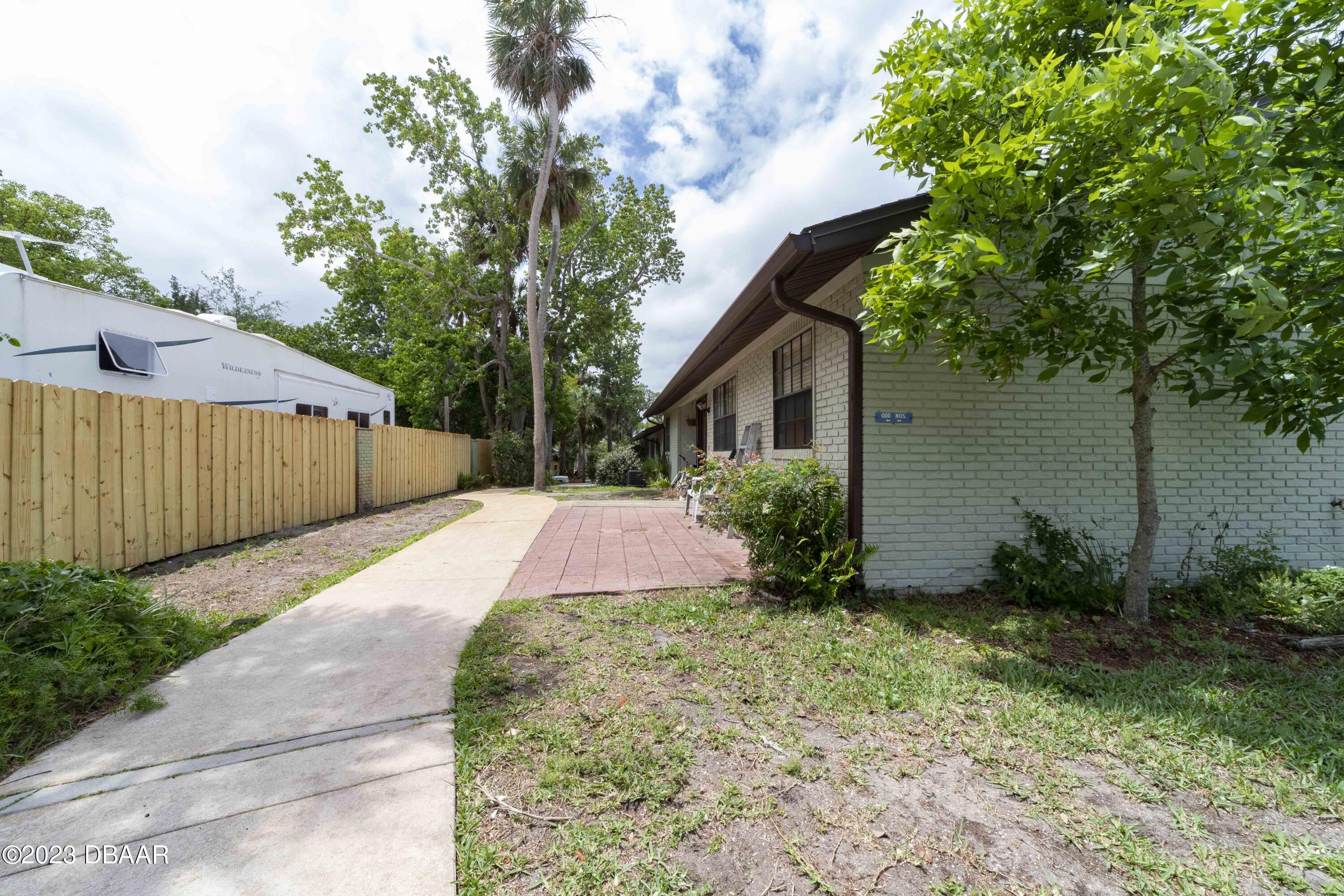 526 Live Oak Street, Unit 1050 Edgewater, FL 32132 - Photo 25 of 26 a backyard of a house with plants and trees