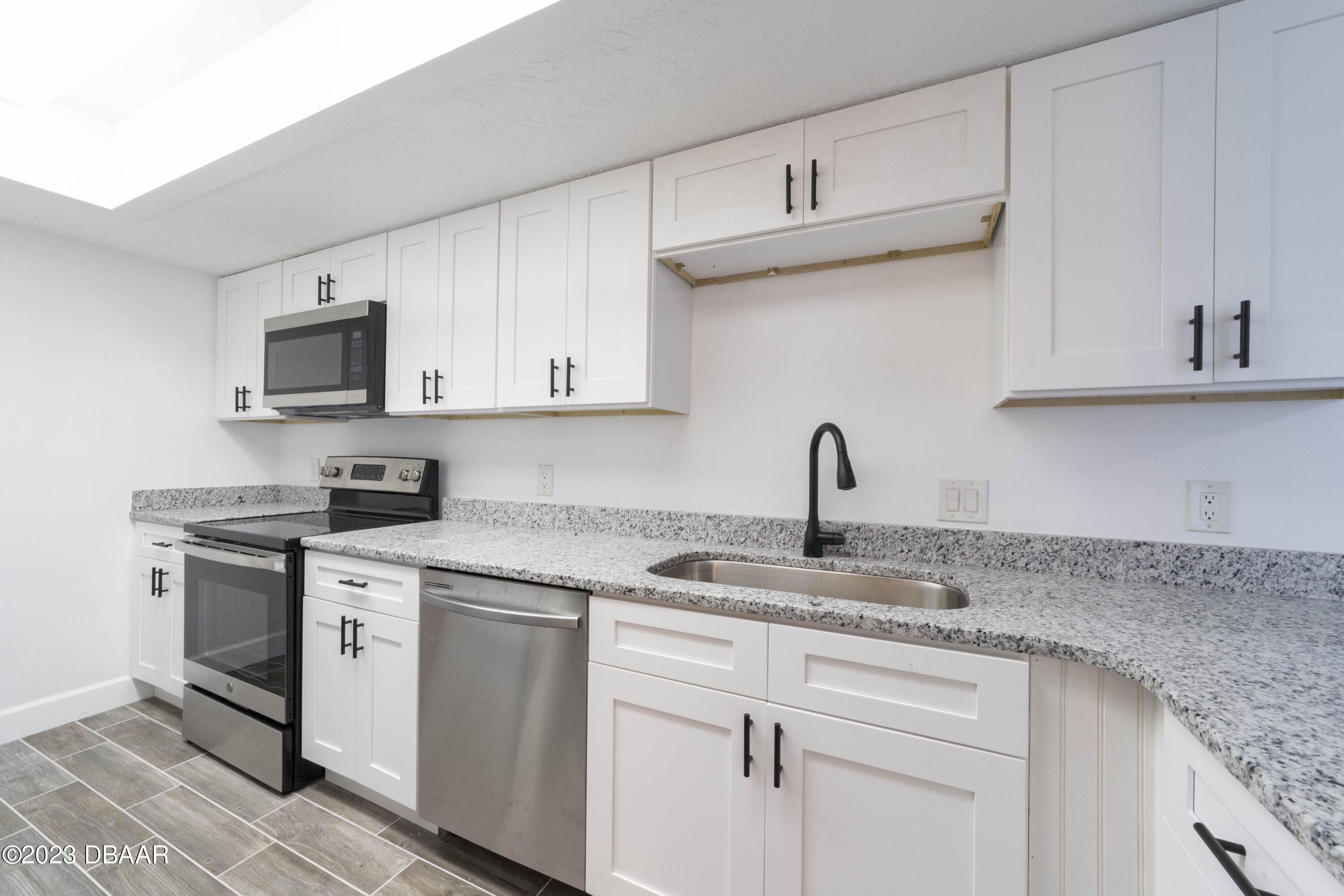 526 Live Oak Street, Unit 1050 Edgewater, FL 32132 - Photo 6 of 26 a kitchen with stainless steel appliances granite countertop a sink and a stove