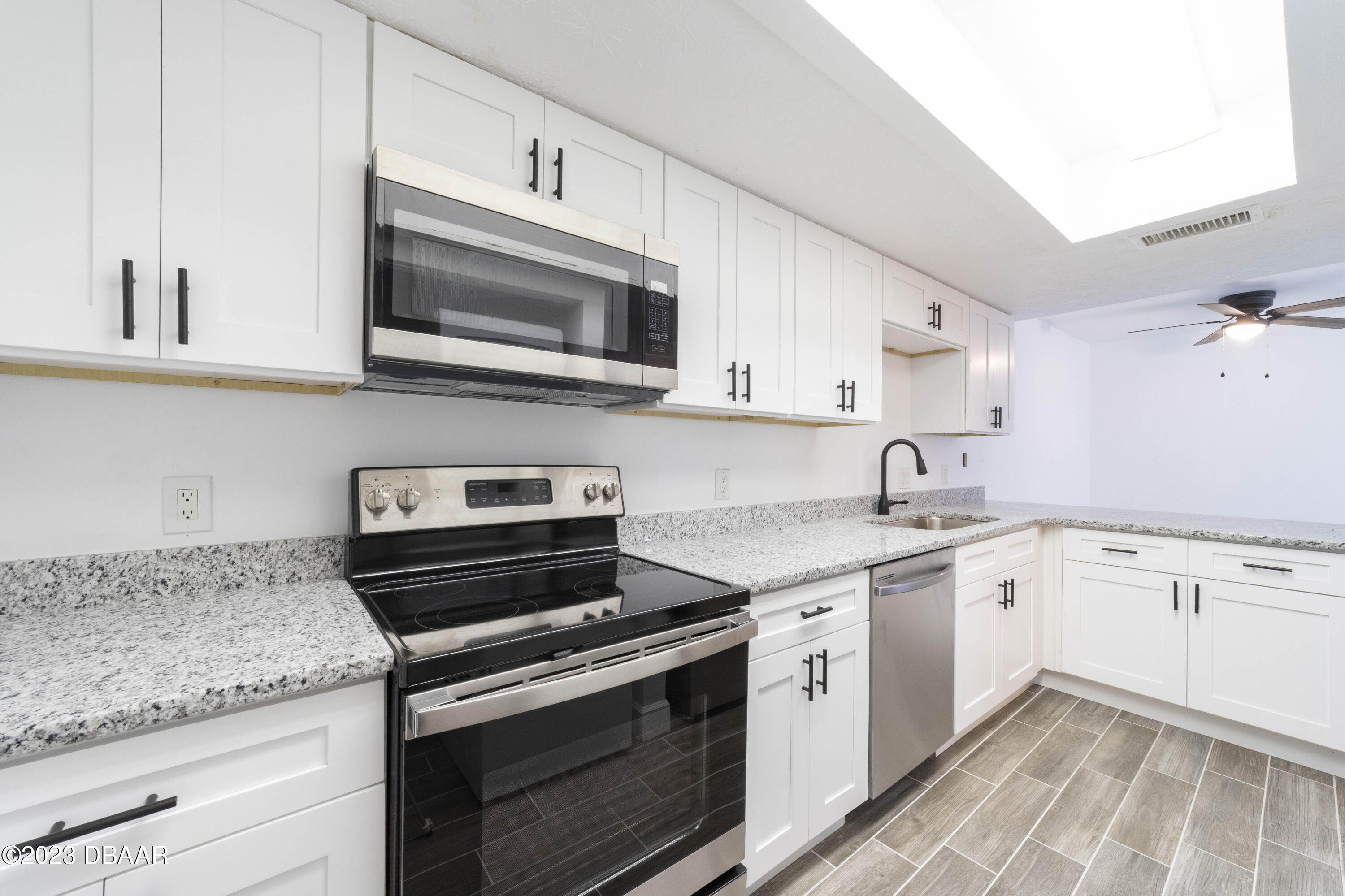 526 Live Oak Street, Unit 1050 Edgewater, FL 32132 - Photo 7 of 26 a kitchen with granite countertop cabinets stainless steel appliances and sink