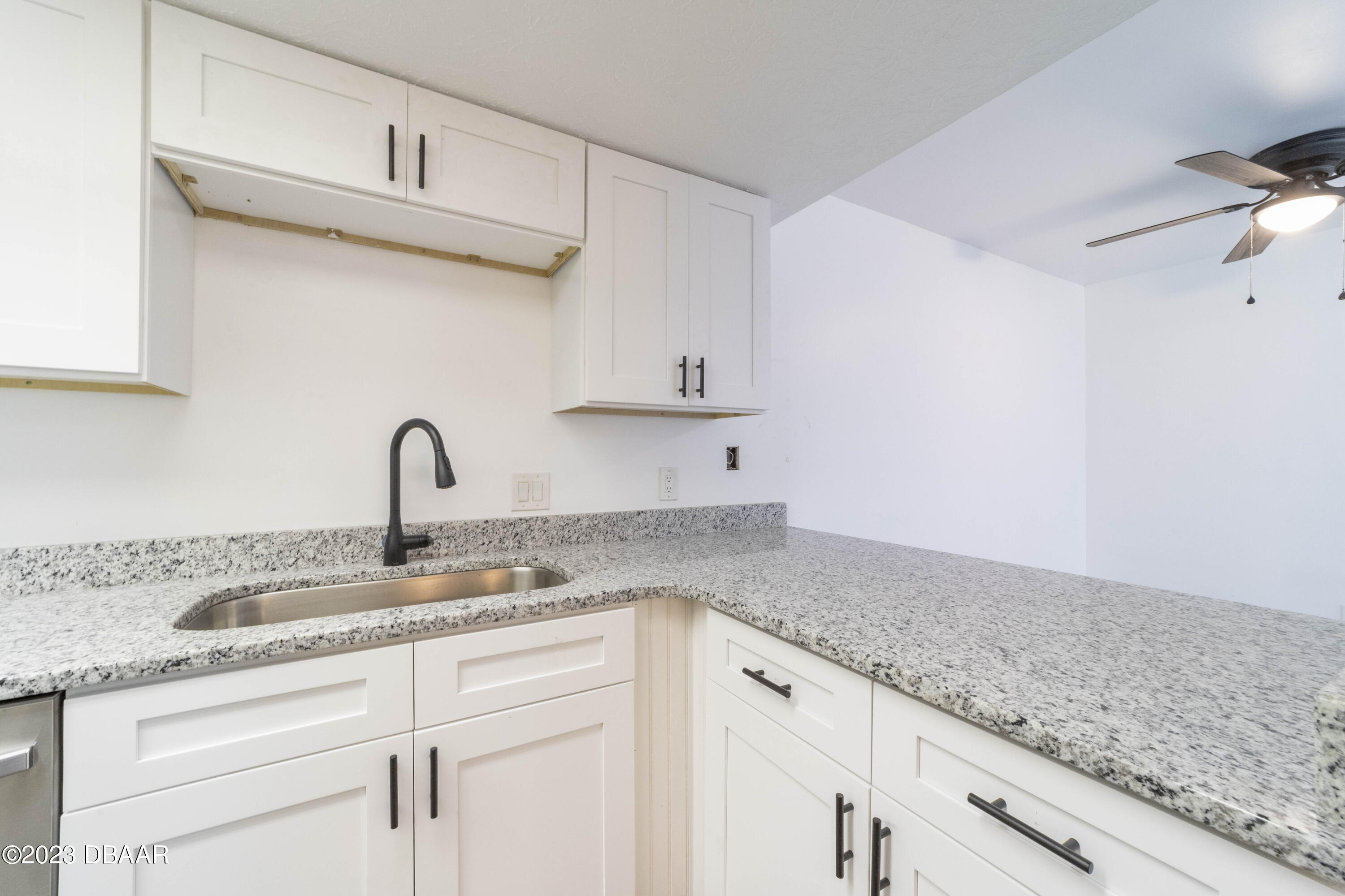 526 Live Oak Street, Unit 1050 Edgewater, FL 32132 - Photo 9 of 26 a kitchen with granite countertop white cabinets and a sink