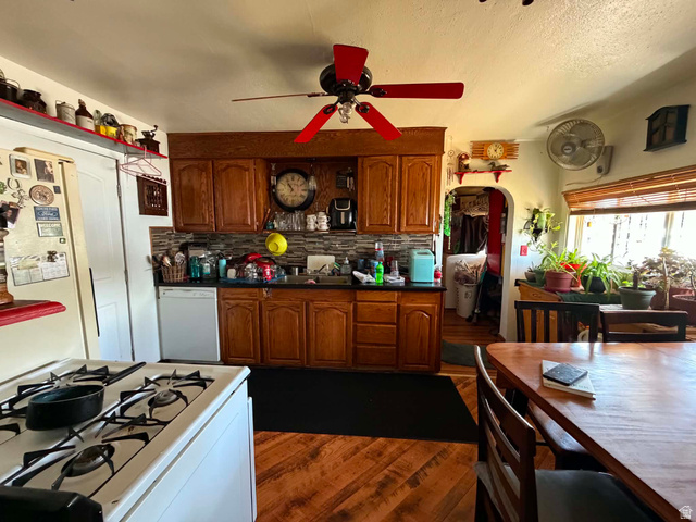 399 2nd E Street Helper, UT 84526 - Photo 4 of 19 Kitchen featuring wood-finish flooring, wood cabinetry, dark countertops, and a tiled backsplash