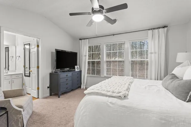 a bedroom with a bed flat screen tv and a couch
