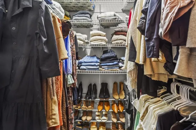 a view of walk in closet with clothes and shoes