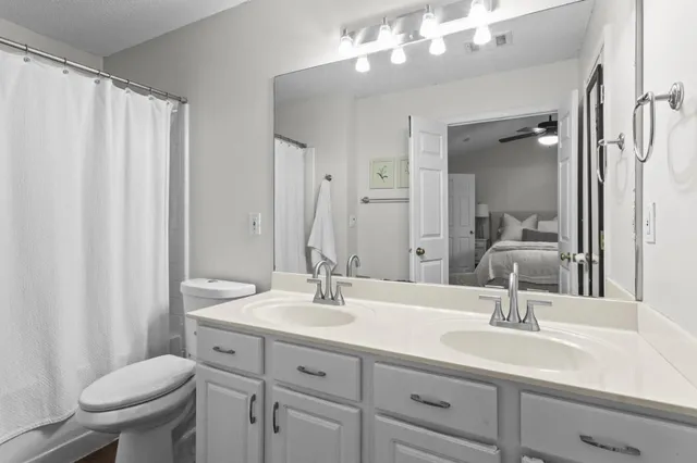 a bathroom with a sink a toilet and a mirror