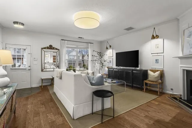 a living room with furniture a flat screen tv and kitchen view