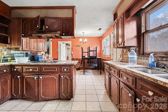 a kitchen with stainless steel appliances granite countertop a sink counter space cabinets and a large window
