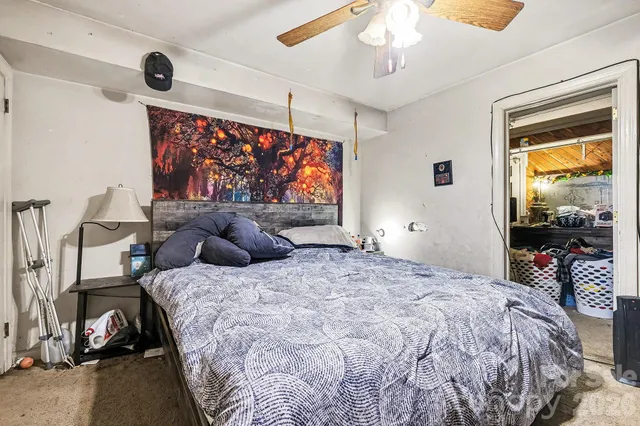 a bedroom with a bed and a large window with the outer view