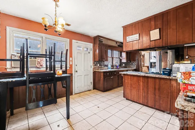 a kitchen with stainless steel appliances granite countertop a refrigerator and a stove top oven
