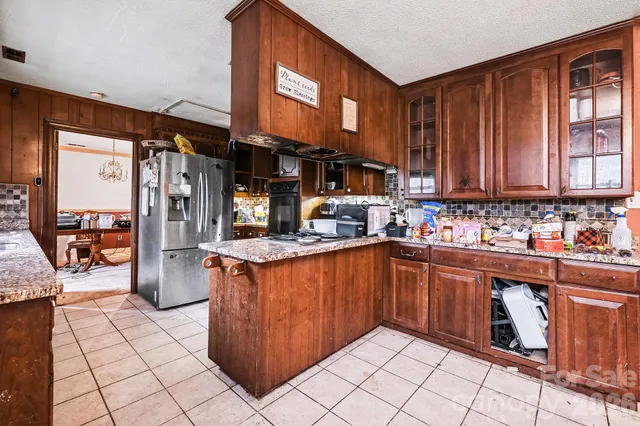 a kitchen with stainless steel appliances granite countertop a refrigerator and a sink