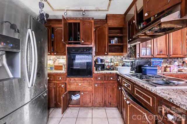 a kitchen with stainless steel appliances granite countertop a refrigerator and a stove top oven
