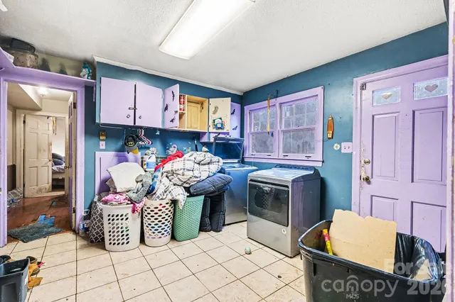 a room with stainless steel appliances kitchen island granite countertop a stove and a refrigerator