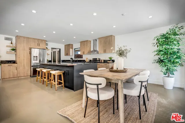 a large kitchen with stainless steel appliances a sink dishwasher a stove and white cabinets next to a window