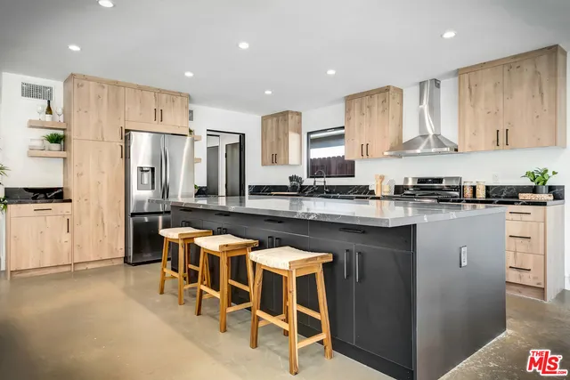 a kitchen with granite countertop a sink white cabinets and stainless steel appliances