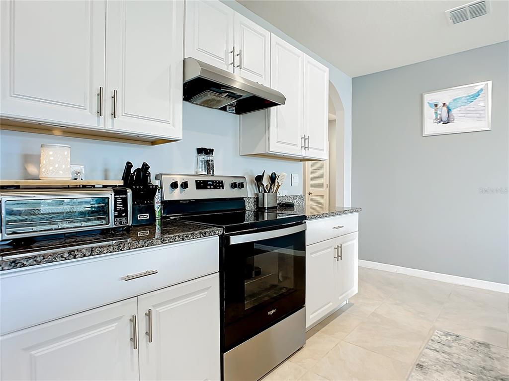 2607 Elmbrooke Way Edgewater, FL 32141 - Photo 17 of 52 a kitchen with stainless steel appliances granite countertop a stove and a white cabinets