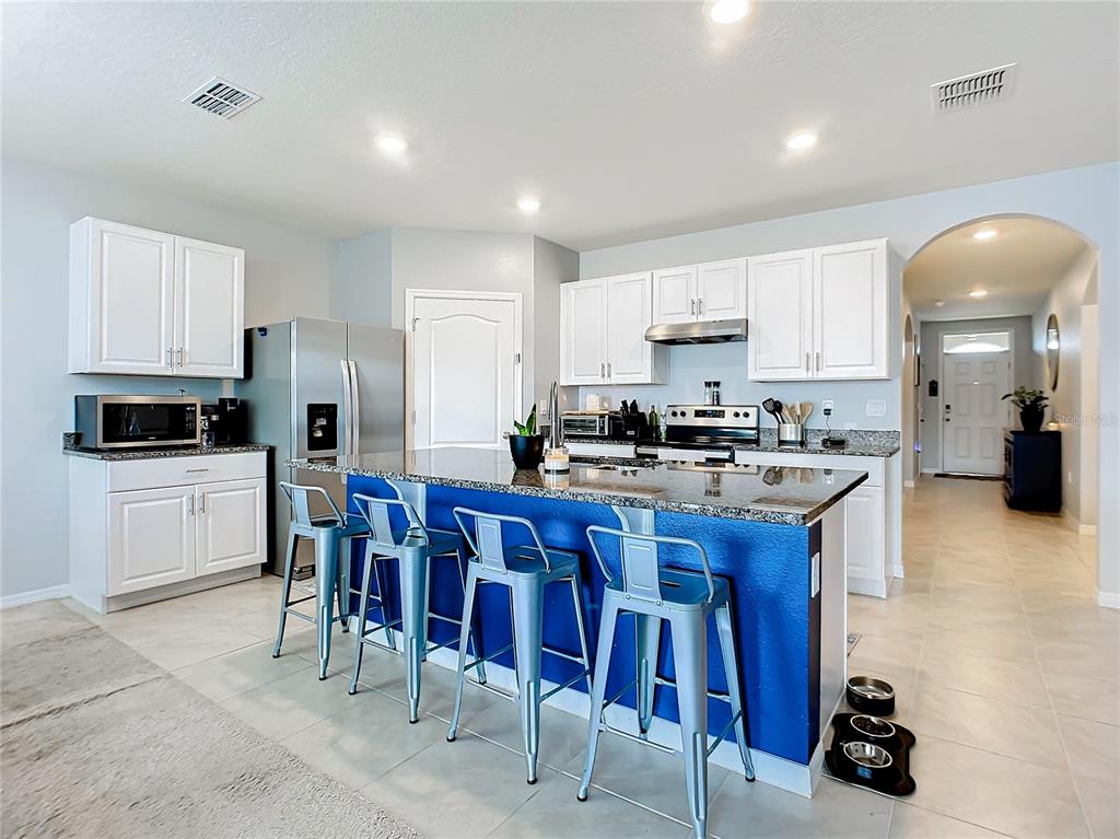 2607 Elmbrooke Way Edgewater, FL 32141 - Photo 2 of 52 a kitchen with stainless steel appliances granite countertop a sink a stove a refrigerator cabinets and chairs