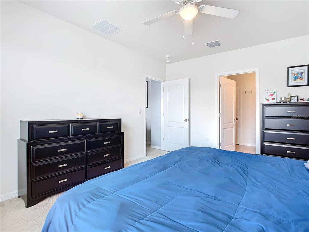 2607 Elmbrooke Way Edgewater, FL 32141 - Photo 38 of 52 a bedroom with a bed and a chandelier