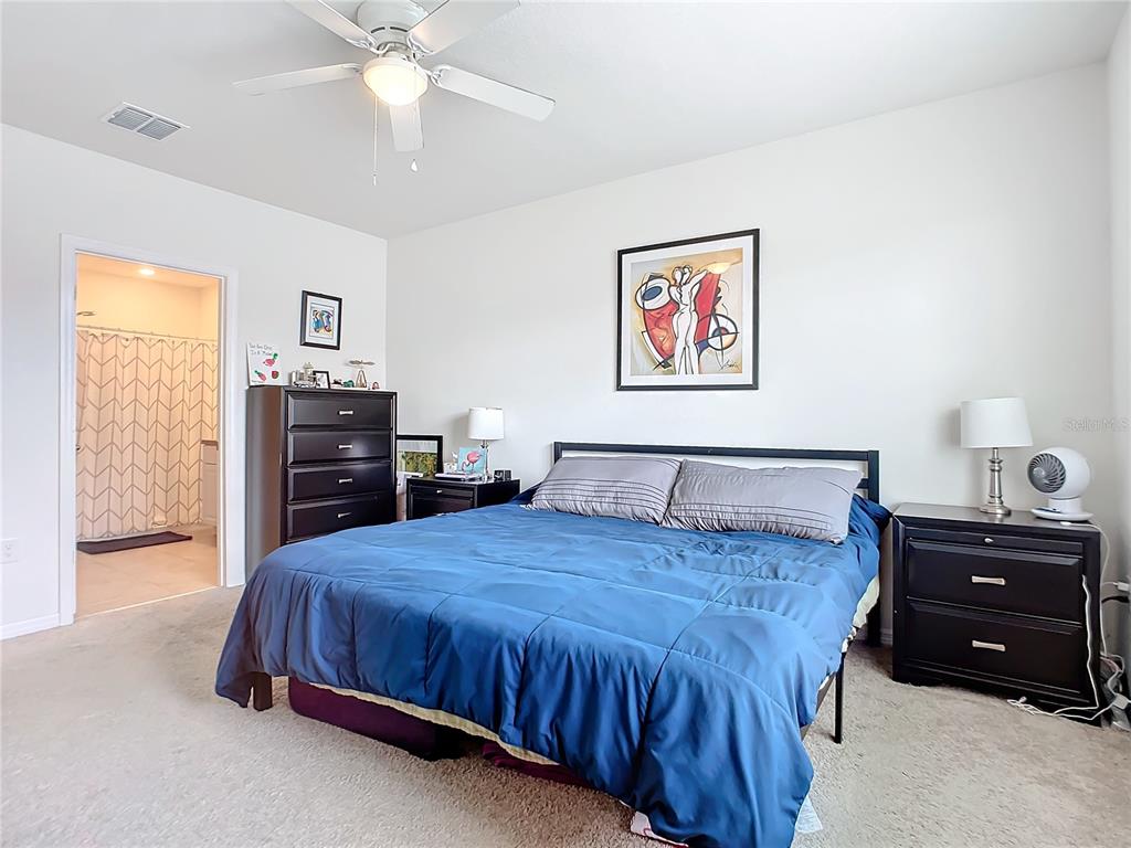 2607 Elmbrooke Way Edgewater, FL 32141 - Photo 39 of 52 a bedroom with a bed and a chandelier