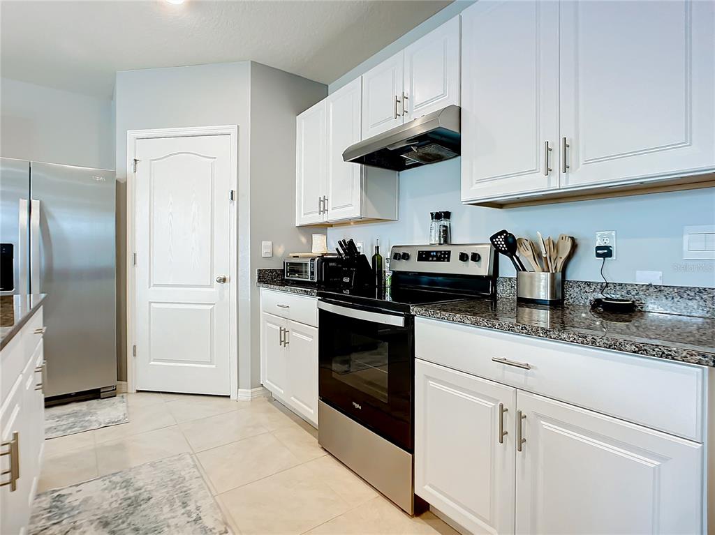 2607 Elmbrooke Way Edgewater, FL 32141 - Photo 4 of 52 a kitchen with stainless steel appliances granite countertop white cabinets a refrigerator a stove a sink and white cabinets