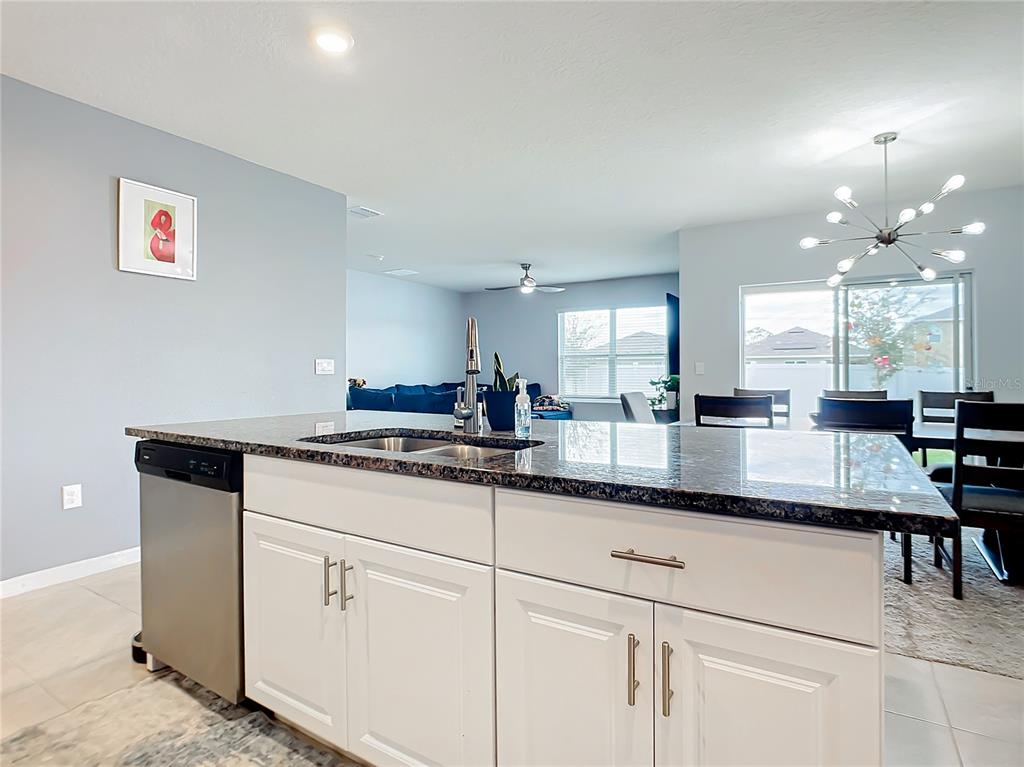 2607 Elmbrooke Way Edgewater, FL 32141 - Photo 5 of 52 a kitchen with granite countertop white cabinets and white appliances