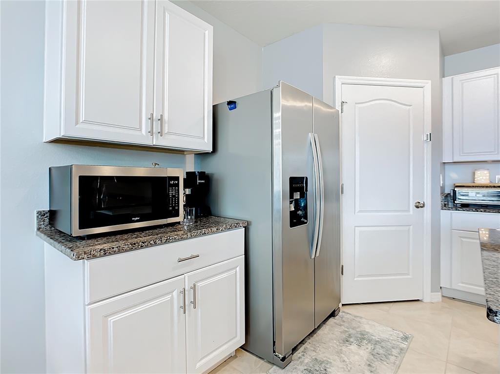 2607 Elmbrooke Way Edgewater, FL 32141 - Photo 6 of 52 a kitchen with stainless steel appliances granite countertop white cabinets and refrigerator