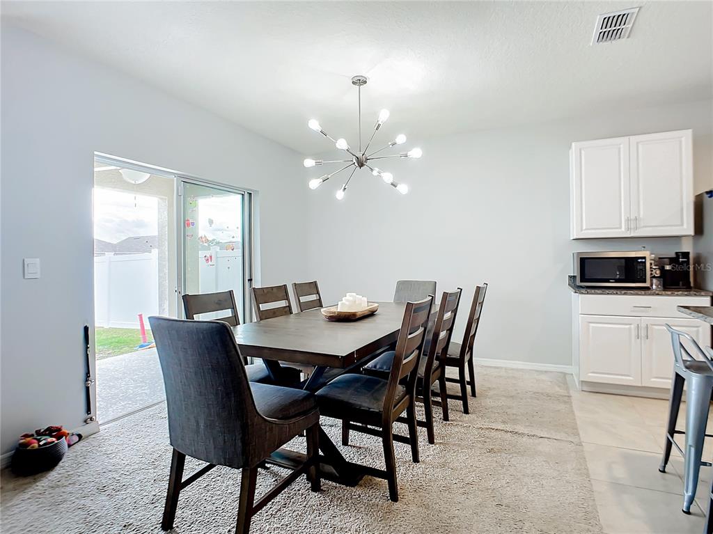 2607 Elmbrooke Way Edgewater, FL 32141 - Photo 9 of 52 a view of a dining room with furniture and a chandelier