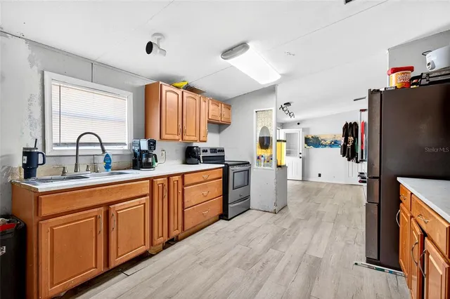 a kitchen with stainless steel appliances a refrigerator sink and cabinets