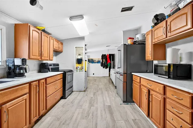 a large kitchen with stainless steel appliances granite countertop a refrigerator and a stove top oven