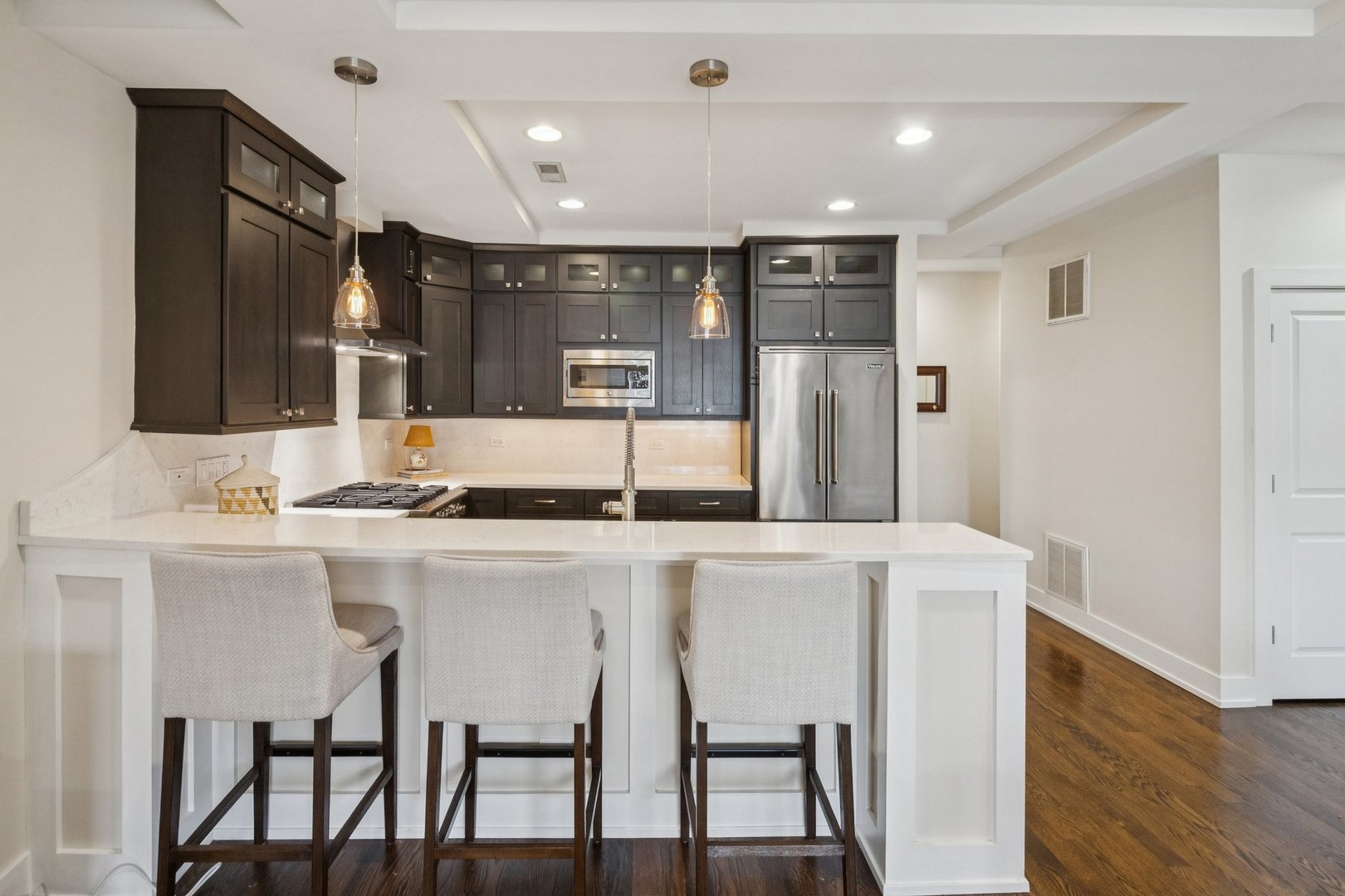 1011 North Wolcott Avenue, Unit 2N Chicago, IL 60622 - Photo 9 of 23 a kitchen with stainless steel appliances kitchen island granite countertop a table chairs sink and cabinets