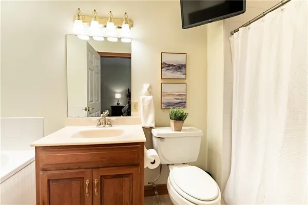 a bathroom with a sink vanity mirror and toilet
