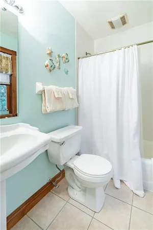 a white toilet sitting next to a white curtain