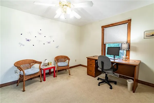 a view of a workspace with furniture and a window