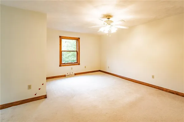 an empty room with windows and chandelier fan