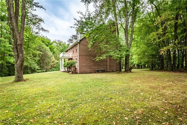 a backyard of a house with plants and large trees