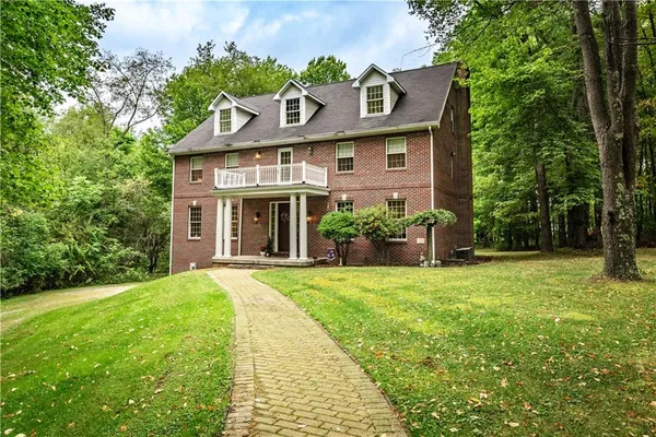 a front view of a house with a yard and trees