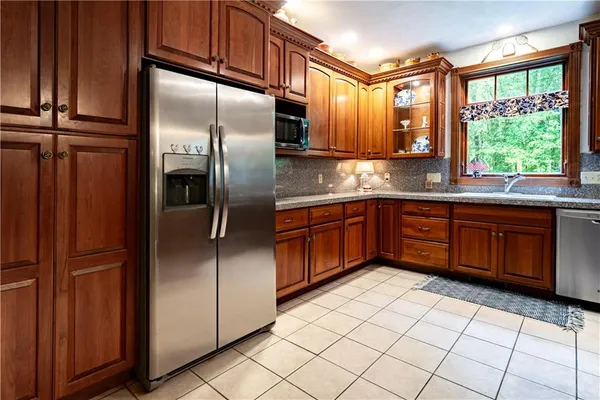 a kitchen with stainless steel appliances granite countertop a refrigerator and a sink