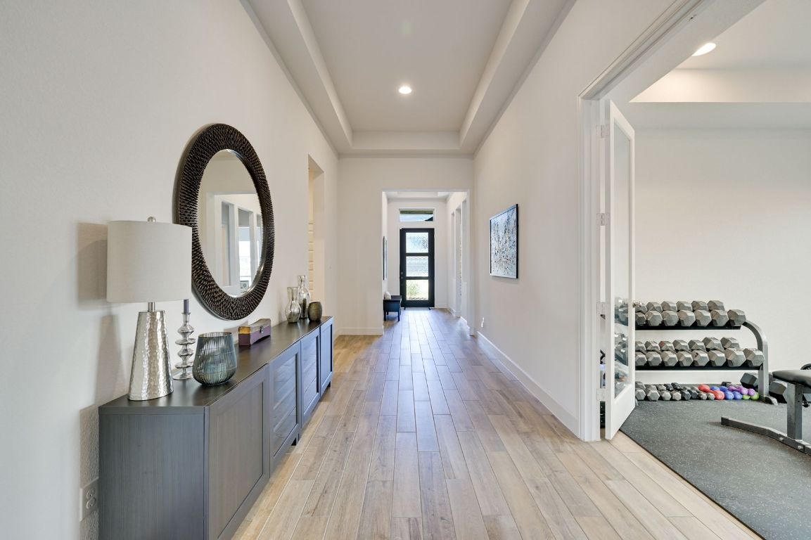 273 Fawn Riv Run Kyle, TX 78640 - Photo 3 of 27 a view of a hallway with entryway wooden floor and front door