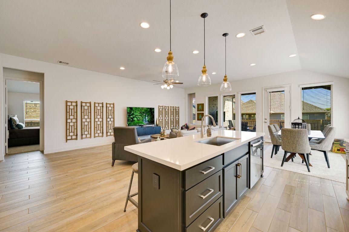 273 Fawn Riv Run Kyle, TX 78640 - Photo 6 of 27 a large kitchen with kitchen island a sink a center island a dining table and chairs