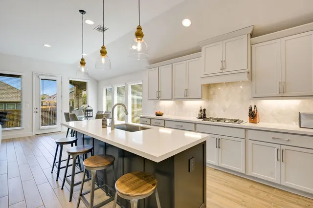 a kitchen with a sink a stove a center island and chairs