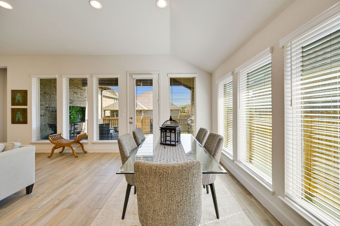 273 Fawn Riv Run Kyle, TX 78640 - Photo 9 of 27 a dining room with wooden floor and large windows