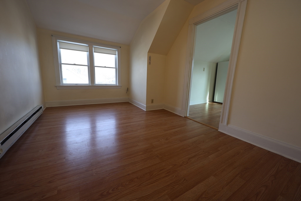 6 Harriet Street, Unit 3 Boston, MA 02135 - Photo 2 of 12 an empty room with wooden floor and windows