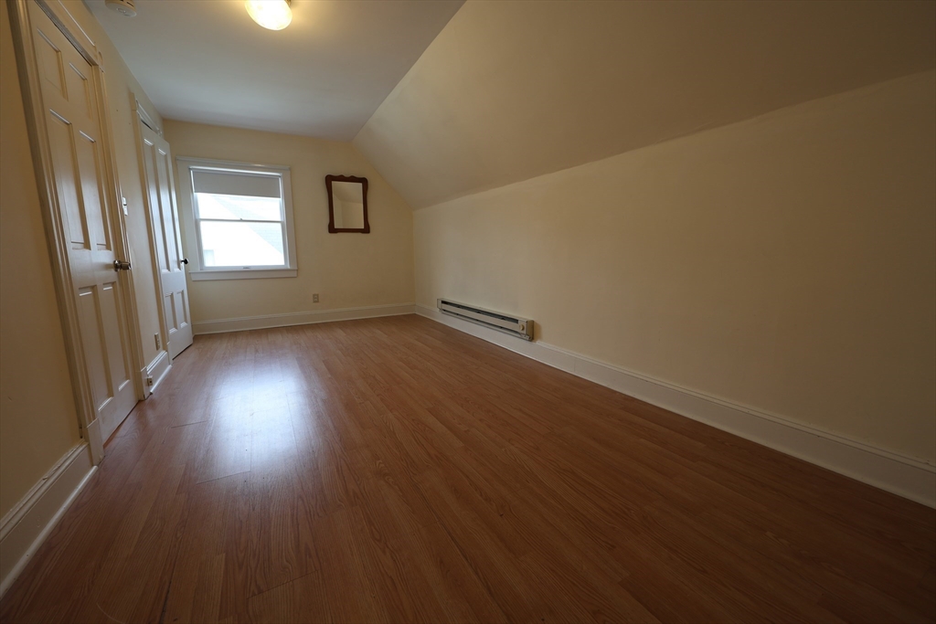 6 Harriet Street, Unit 3 Boston, MA 02135 - Photo 3 of 12 an empty room with wooden floor and windows