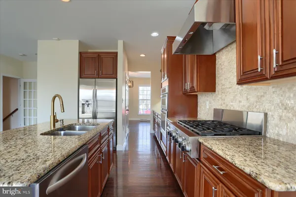 a kitchen with stainless steel appliances granite countertop a sink stove and cabinets