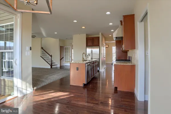 a view of kitchen with stainless steel appliances refrigerator stove microwave and cabinets