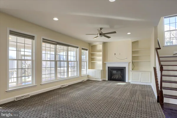 a view of an empty room with a fireplace and a window