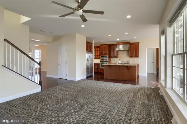 a view of kitchen with kitchen island wooden floor center island stainless steel appliances wooden floor and window