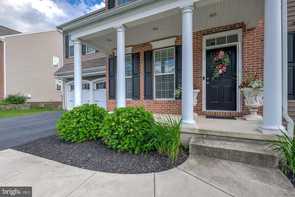 front view of a brick house with potted plants