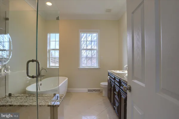 a bathroom with a tub sink and mirror