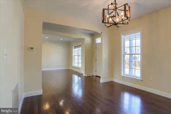 a view of a livingroom with a wooden floor and a chandelier