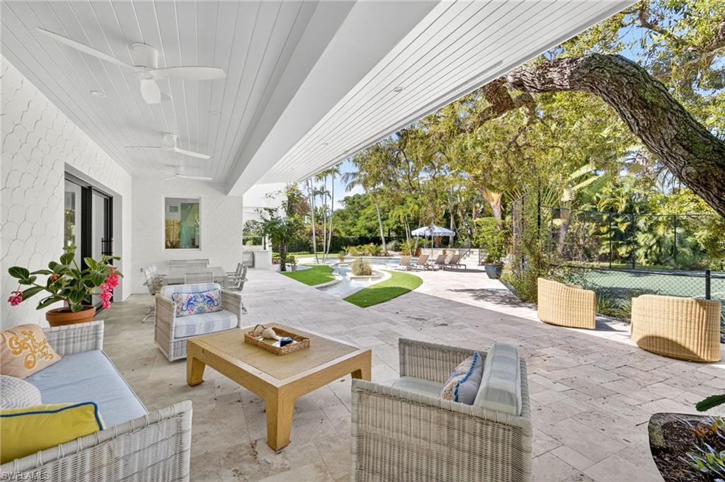 111 Caribbean Road Naples, FL 34108 - Photo 3 of 50 a living room with patio furniture and potted plants